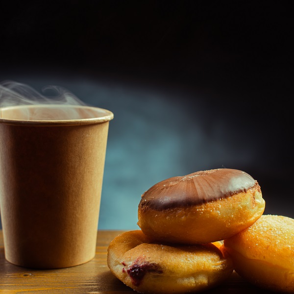 Cup of hot coffee with a stack of donuts